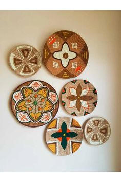 four woven coasters are arranged on the wall