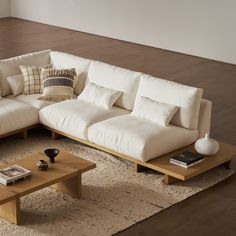 a white sectional couch sitting on top of a wooden coffee table