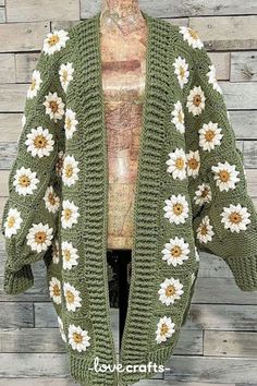 a green crocheted cardigan with white and yellow flowers