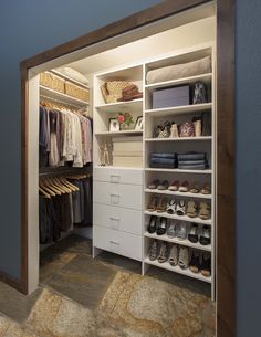 an organized closet with white drawers and shelves filled with clothes, shoes and other items