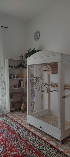 a large white bird cage sitting on top of a rug