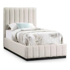 a bed with a white headboard and pillows