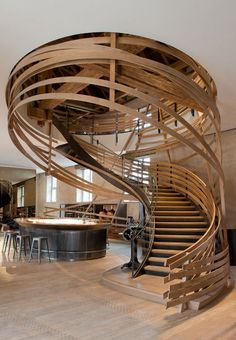 a spiral staircase in the middle of a living room next to a kitchen and dining area