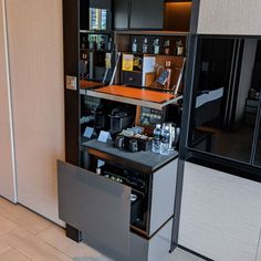 an open cabinet in the corner of a room with coffee machines and other items on it