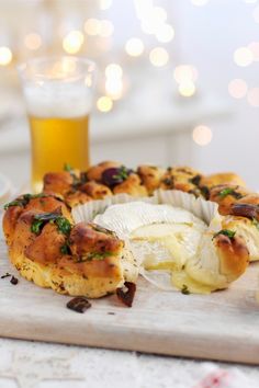 some food is laying out on a cutting board next to a glass of beer and other items