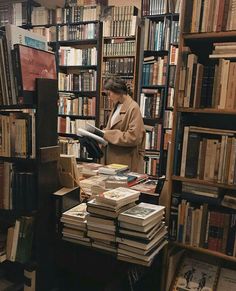 a person standing in front of a book shelf filled with books and looking at it