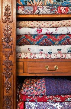 a wooden shelf filled with lots of colorful fabrics