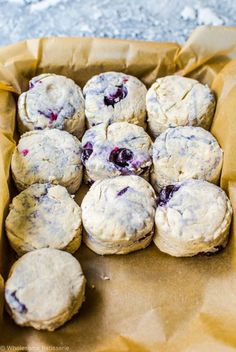 blueberry muffins sitting in a brown paper bag on top of a table