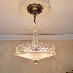 a chandelier hanging from the ceiling in a room with beige walls and flooring