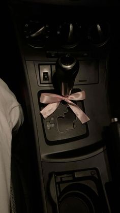 the interior of a car with a pink bow on it's dash board and steering wheel