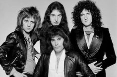 an old black and white photo of four men with long hair, wearing leather jackets