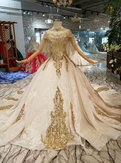 a dress on display in a store with gold sequins and beaded detailing