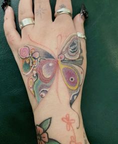 a woman's hand with a butterfly tattoo on it