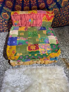 a multicolored blanket sitting on top of a white rug