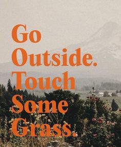 the words go outside, touch some grass are in front of a mountain and trees