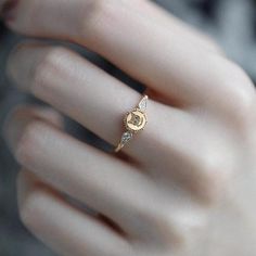 a close up of a person's hand wearing a gold ring with the letter c on it