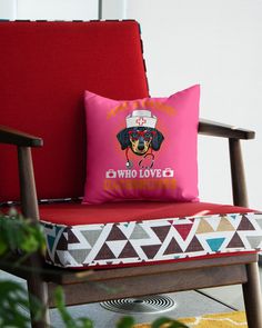 a dog pillow sitting on top of a red chair next to a pink throw pillow