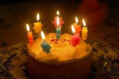 a birthday cake with lit candles on it