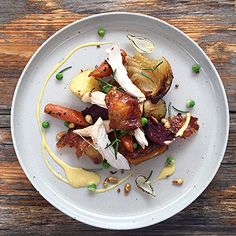 a white plate topped with meat and veggies on top of a wooden table