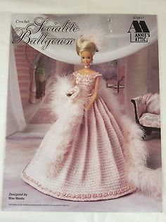 a barbie doll in a pink dress with feathers