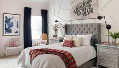 a bedroom with pink walls and white carpeted flooring is decorated in gray and red