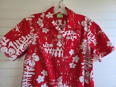 "RARE WOMEN'S HAWAIIAN BLOUSE! This is a fantastic 1960s Ui-Maikai vintage blouse! MOD white FLOWERS on a bright red background make this a wonderfully vintage Hawaiian blouse to add to your wardrobe. Well tailored of medium weight Hawaiian fabric - marked \"POLYNESIAN TEXTILES D/# 5492\" Looks great with jeans, shorts and skirts. Size: Women's M (based on measurements) Measurements: 19 1/2\" armpit to armpit 15\" across shoulders 26 1/2\" back neckline to hem Features: 100% Cotton Made in Hawaii Front darts Horizontal buttonholes 4 buttons down front EXCELLENT CONDITION! Clean and ready to wear. A PORTION OF THE PROFITS FROM TheloniousPBear is DONATED to POLAR BEARS INTERNATIONAL. Thank you for visiting! MORE TO SEE at: https://www.etsy.com/shop/TheloniousPBear Please visit our other shop Retro Short Sleeve Blouse For Beach, Retro Short Sleeve Blouse For Vacation, Retro Fitted Blouse For Vacation, Fitted Retro Blouse For Beach, Fitted Vintage Blouse For Vacation, Retro Fitted Hawaiian Shirt For Beach, Retro Fitted Hawaiian Shirt For The Beach, Fitted Retro Hawaiian Shirt For Beach, Retro Fitted Beach Shirt