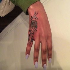 a woman's hand with a flower tattoo on it