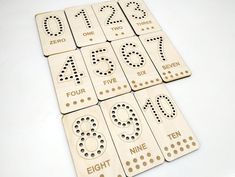 four wooden numbers and nines are arranged on a white surface with holes in the middle