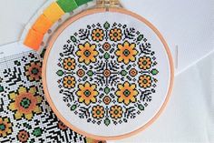 a cross - stitch pattern with flowers on it and a piece of fabric next to it