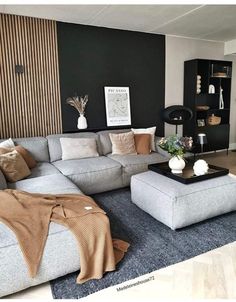 a living room filled with lots of furniture next to a wall covered in black and white art