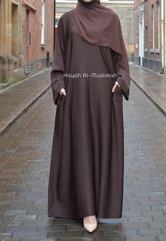 Our premium textured plain brown abaya is made from highest quality of polyester and crepe fabric. Extreme care is taken during the manufacturing process to ensure the fit and the stitching quality is at the optimum standard giving you the premium feel where compromise is not an option. The Brown Textured Abaya features Zip pockets in the seam of the abayas which remains hidden and is perfect for daily and casual wear. Ideal for Hajj, Umrah, Ramadan and daily wear. Also available in Nida and var Umrah Dress For Ladies, Plain Abaya Designs, Umrah Outfit For Women, Abaya For Umrah, Niqab Ideas, Daily Abaya, Brown Abaya, Hijab Fabric, Simple Abaya Designs