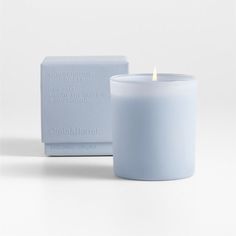 a white candle sitting next to a blue box