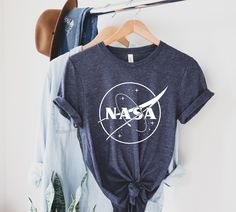 NASA Shirt | Nasa Space Shirt - Nasa Logo Tee - Space Shirt- NASA Space t-shirts -Top Trends shirt- Space shirt- Nasa gift-Graphic tees GUIDANCE *All our simple color t-shirts are 100% Cotton. *All our Heather Color t-shirts are 90% cotton 10% polyester blend and they are extremely snug. Our design are made very professionally with the right equipment *Soft and High-Quality Fabric *Taped shoulder-to-shoulder *Tear away label *Retail fit *Pre-shrunk * Side Seamed *Design size and placement is app Nasa Gifts, Nasa Shirt, Nasa Logo, Space Shirts, Nasa Space, Sugar Land, Logo Tee, Kids Sweatshirt