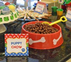 there is a bowl full of dog food on the counter next to a sign that says puppy chow