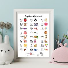 the english alphabet poster is displayed next to a toy and other items on a table