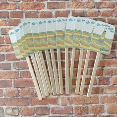 four wooden paddles are hanging on a brick wall with an image of the ocean