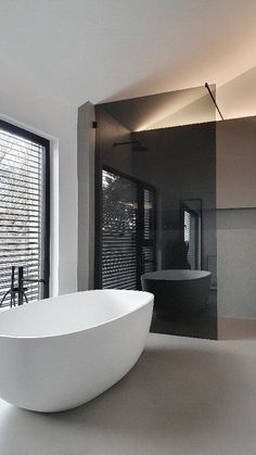 a large white bath tub sitting next to a window