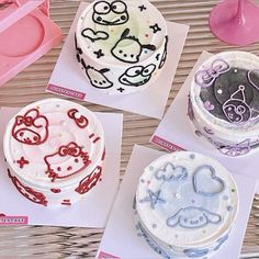 three cakes decorated with hello kitty designs on paper