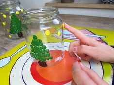 a person is making a miniature cactus in a jar