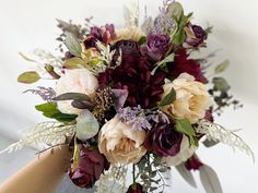 a bouquet of flowers is being held by someone's hand on a white background