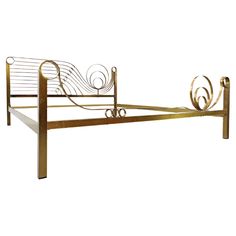 a metal bed frame with an intricate design on the headboard and foot board, against a white background