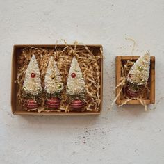 three small christmas trees are in a box