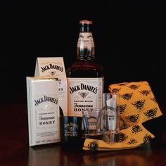 a bottle of jack daniels sitting next to some glasses and napkins on a table