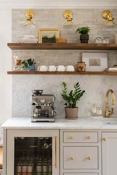 a kitchen with marble counter tops and shelves filled with coffee pots, cups, and plants