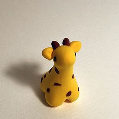 a toy giraffe sitting on top of a white table