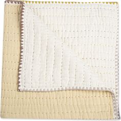 a close up of a blanket on top of a white table cloth with yellow trim