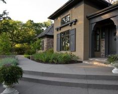 a house with steps leading up to the front door and landscaping in front of it