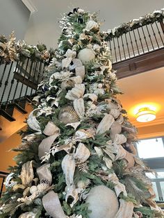 a christmas tree decorated with white and silver ornaments