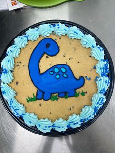 a blue dinosaur cake sitting on top of a table