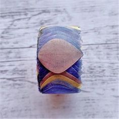 a close up of a ring made out of glass on a wooden table with white background